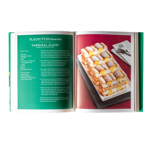 Der Holzbalkon mit Glasgeländer bietet an einem sonnigen Tag einen Blick auf einen grasbewachsenen Hinterhof und die Häuser der Nachbarschaft.