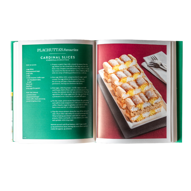 Der Holzbalkon mit Glasgeländer bietet an einem sonnigen Tag einen Blick auf einen grasbewachsenen Hinterhof und die Häuser der Nachbarschaft.